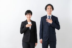 胸に手を当てて安心しているスーツ姿の男女